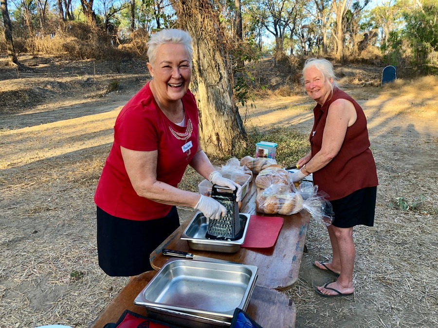 two ladies preparing dinner at camp