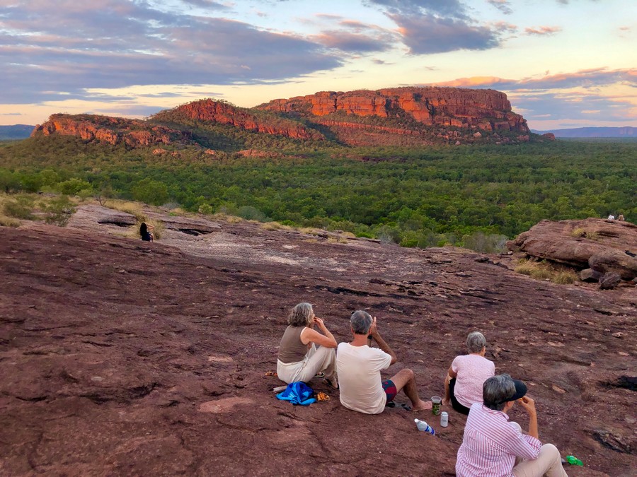 people sitting on lookout over red rock