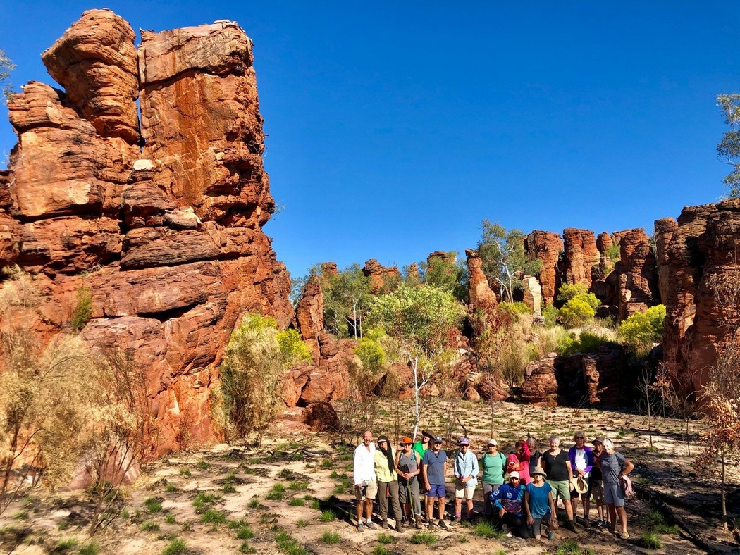 people in front of large sand stone structure northern territory