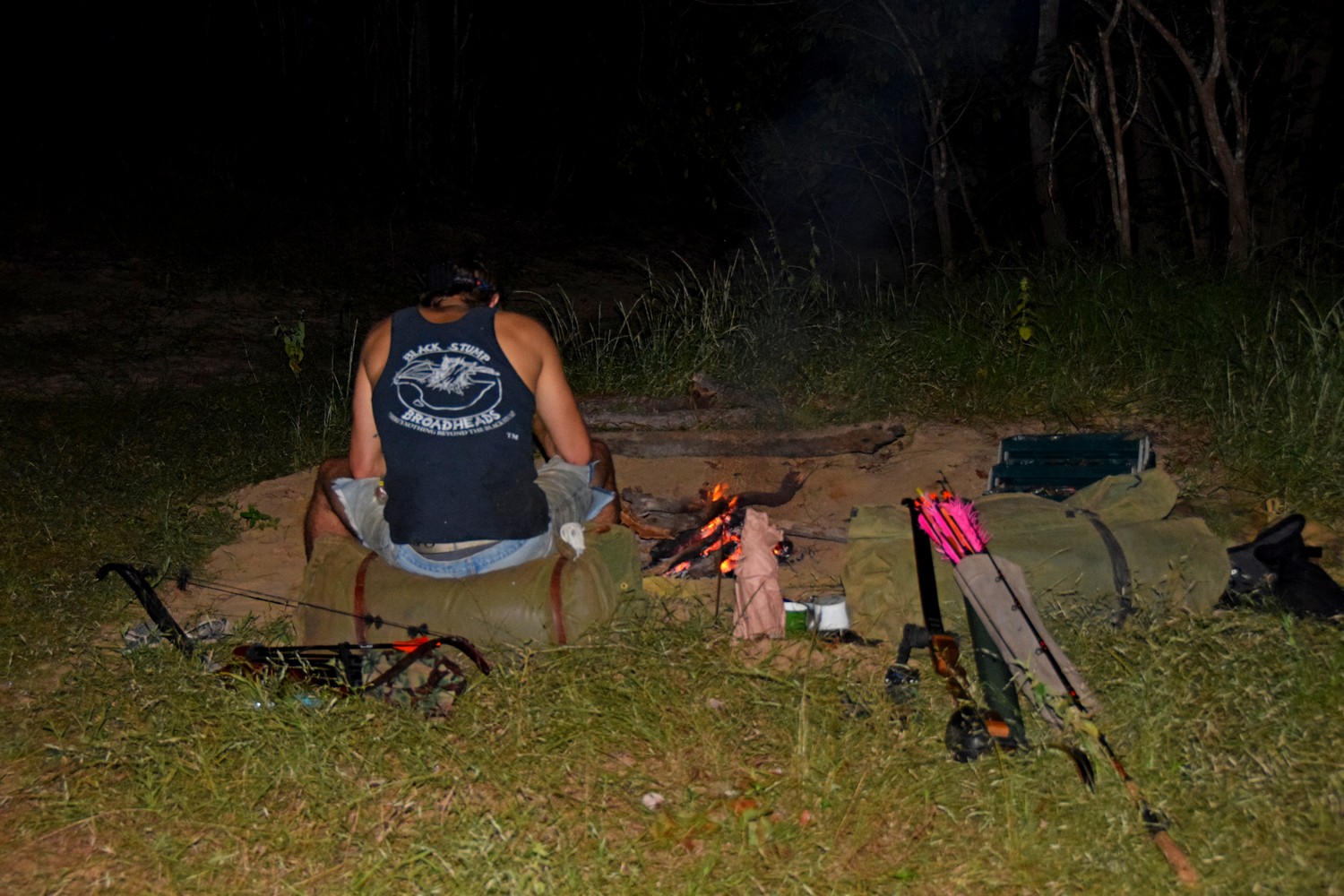 man sitting by fire preparing