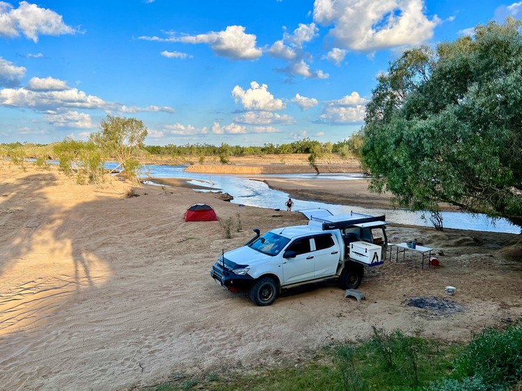 4wd ute with tent setup next to river