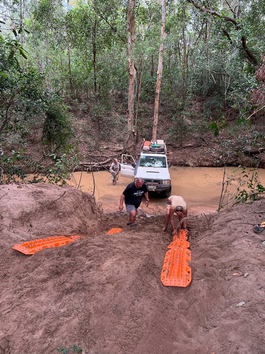 men using max trax in creekbed